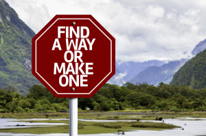 Find A Way Or Make One written on red road sign with landscape b