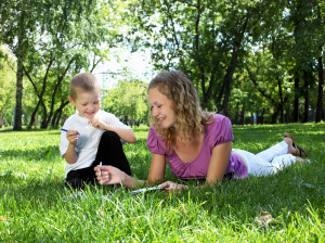 Mother with little son in the park reading a book