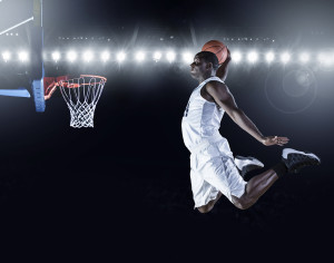 Basketball Player scoring an athletic, amazing slam dunk
