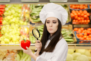 Concerned  Lady Chef Inspecting Vegetables with Magnifying Glass
